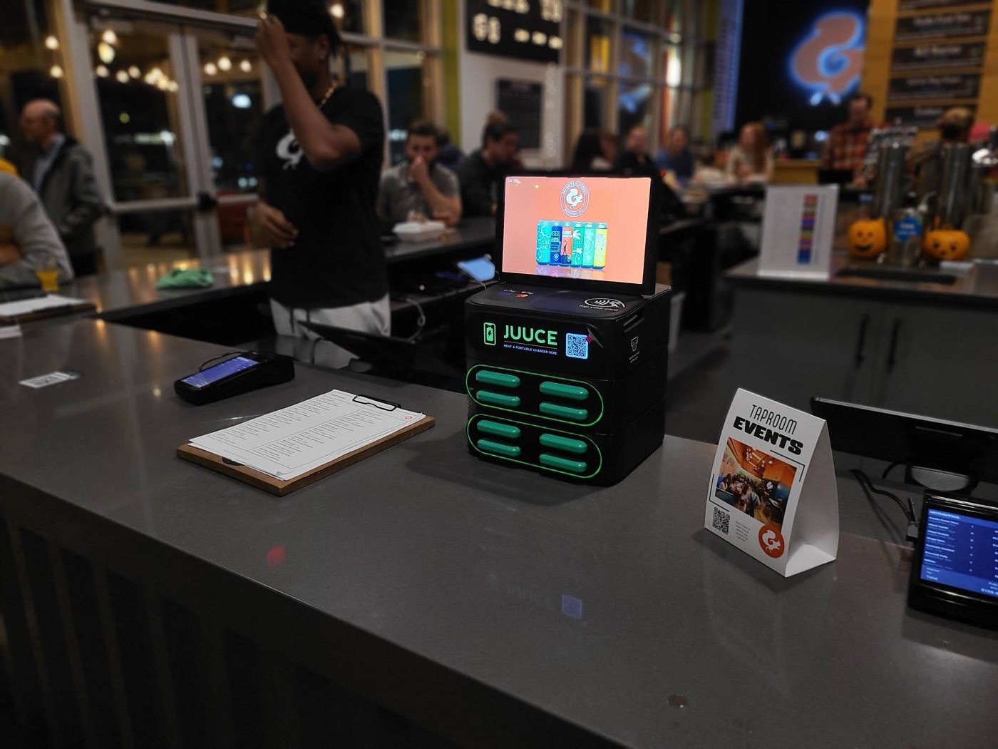 A JUUCE station on the counter of a busy taproom